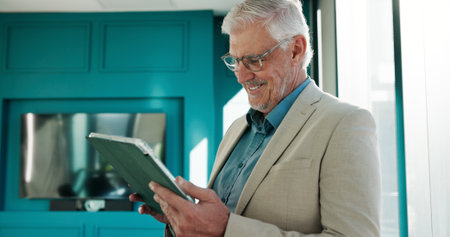 Office, tablet and mature business man for online website, finance report and investment research. Corporate, professional and person on digital tech for financial review, networking and planningの写真素材