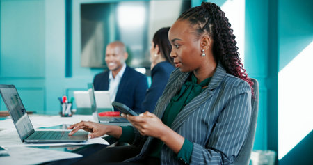 Reading, coworking or businesswoman on laptop with phone, online research or economy website. Meeting, check or financial advisor in office with mobile app for text message, finance report or updateの写真素材