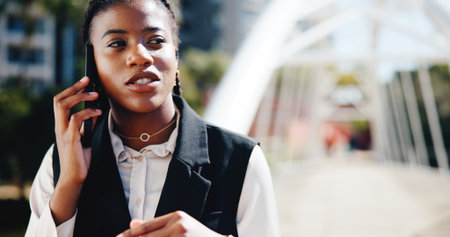 Business woman, phone call and talk in city with networking, contact and perspective on commute. African person, smartphone and discussion in town with communication, feedback and listen in Nigeriaの写真素材