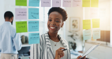 Business woman, schedule and planning with glass board for reminder, project or tasks in office. Female person, planner or agenda with smile for brainstorming ideas, notes or deadline in workplaceの写真素材