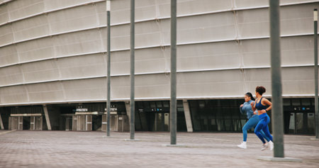 Running, athlete and women on race, energy and practice for competition, speed or outdoor for sport. Fast, runner or training for marathon in city, African people and exercise for fitness or spaceの写真素材