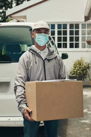 Portrait, parcel or face mask for delivery man by car with courier for shipment, e commerce or package. House, transport vehicle or service with box for postage, safety compliance or online shoppingの写真素材