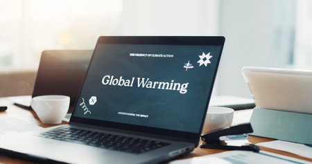 Global warming, laptop screen and computer on desk in office for website, information or research. Business, empty and tech with online article for environmental cause, climate change or conservationの写真素材