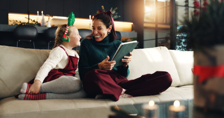 Christmas, happy mom and kid with tablet in home for holiday, love and care. Xmas, parent and girl...