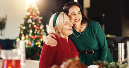 Hug, Christmas and woman with senior parent for vacation, bonding and excited. December, holiday or festive season with family, mature mother and celebration with smile and social gathering in homeの写真素材