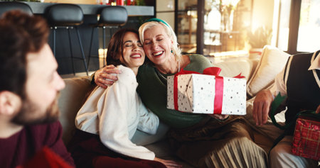 Hug, Christmas gift and woman with senior parent for vacation, bonding and excited. December,...