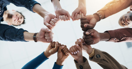 Below, business and people with fist together for team building, solidarity and trust with...