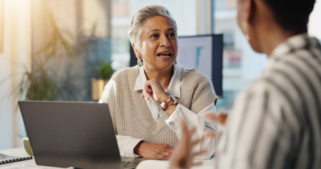 Manager, business women and conversation in office for financial ideas, briefing or progress update. Mature CEO, discussion or planning for accounting, brainstorming solution or audit in team meetingの写真素材