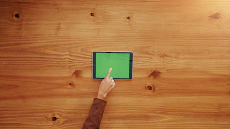 Green screen, tablet and hands of businesswoman in office for research, email or networking. Chroma key, pointing and team of corporate employee with digital technology for communication by table.の写真素材