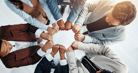 Teamwork, fist bump and above of business people in office for solidarity, agreement and partnership. Professional, corporate and workers together for collaboration, support and coworking synergyの写真素材