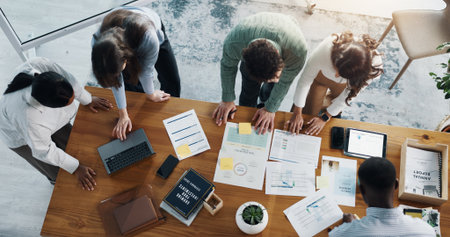 Documents, technology and team of business people in office with planning for investment growth. Paperwork, discussion and group of financial advisors with statistics for profit report from above.の写真素材