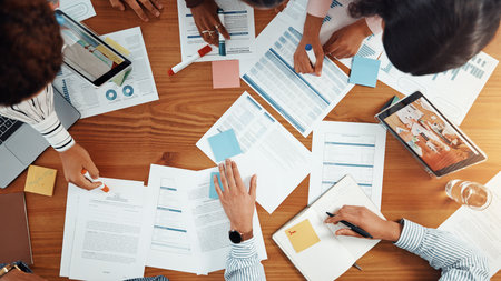 Above, business people and discussion in meeting with graphs, data analysis and feedback. Teamwork, collaboration and documents for project, research and tech for chart review with paperwork or notesの写真素材