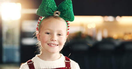 Portrait, Christmas and girl with bow, kid and home with happiness, festive and tradition....