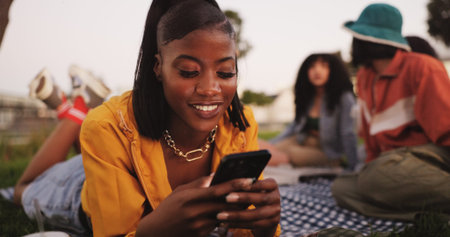 Texting, woman and smartphone on picnic, outdoor or smile for communication with contact and online....