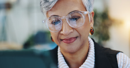 Smile, woman and reading on tablet in office for editor agenda, information and article post. Mature journalist, glasses and reflection of digital for proofreading, update draft and story publicationの写真素材