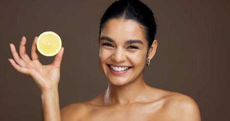 Beauty, woman and portrait with lemon in studio for natural skincare, dermatology or vitamin c on background. Healthy glow, citrus fruit and sustainable antiaging with clean skin or self careの写真素材