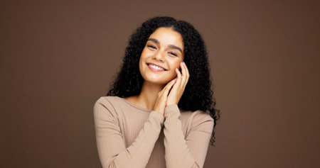Cosmetics, portrait and woman in studio for beauty, makeup or positive for facial glow. Smile, natural and female person from Colombia with face cosmetology for confidence by brown background.の写真素材