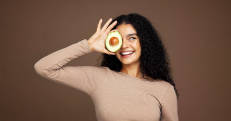 Smile, woman and avocado for skincare in studio for vitamin c, brighten skin and natural detox....