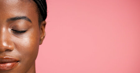 Half, face and facial treatment for woman, wellness or dermatology for glow of smooth skin or shine. Studio background, beauty and black person with eyes closed, mockup space or cosmetic for selfcareの写真素材