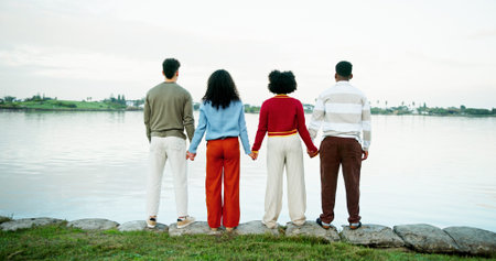 Holiday, nature and friends holding hands at lake with trip support, view and vacation sightseeing....