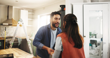 Dance, diy and renovation with couple in kitchen of apartment together for home improvement. Celebration, maintenance and music with people in new house for remodeling, repairs or restorationの写真素材
