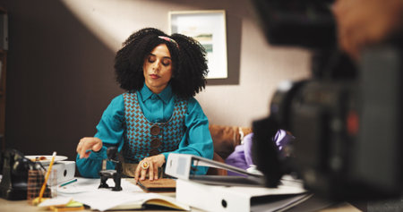 Creative, actor and woman on movie production, cinematography and shooting of scene with technology. Person, acting and equipment for filming on set, cast and serious for entertainment, art or cameraの写真素材