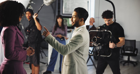 Man, actor or camera with scene in production studio for action, take or roll play on set. Male person, crew or cast in character for film making, movie or recording for cinematography or videographyの写真素材