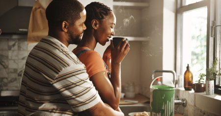 Home renovation, paint and couple with coffee, hug or romance on break in kitchen, love and morning. Happy, black man and woman with caffeine, bonding or remodeling of new house, color or maintenanceの写真素材
