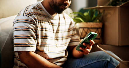 Phone, hands and moving with man in new home for property investment, relocation options or email. Mobile, real estate and person in house with message for rent, mortgage or shop online for furnitureの写真素材