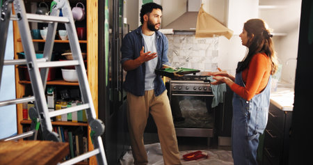 Home improvement, argument and couple with paint, kitchen and fight for color of apartment or decor. Angry, black man and woman with conflict in new house, disagreement and discussion for remodelingの写真素材