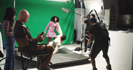 People, acting and filming with stabilize in studio for commercial, production process and record. Crew, actor and actress with cameraman on set for shooting scene, action movie and rehearsal footageの写真素材
