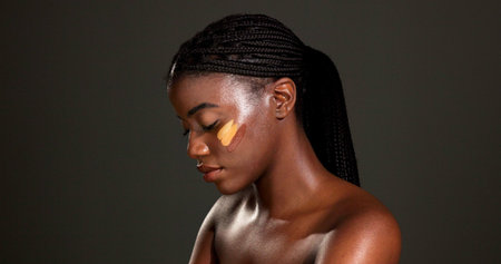 Black woman, makeup and beauty with shade in studio for foundation choice on dark background. Female...
