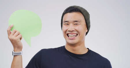 Portrait, happy Asian man and speech bubble in studio for voice, faq or funny joke with mockup...