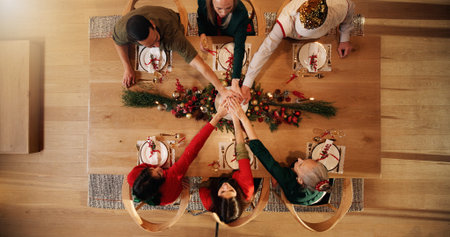 Stack of hands, christmas and people in home for bonding, celebration or event in dining room....