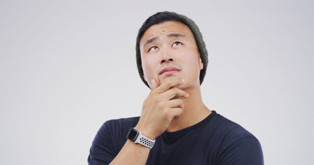 Thinking, choice and man in studio with uncertain for decision, brainstorming or question. Ideas,...