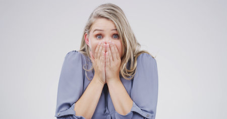 Surprise, shock and portrait of woman in studio with bad news, announcement and omg. Face expression, wow and cover mouth with model for gossip, secret and drama with wtf on white background spaceの写真素材