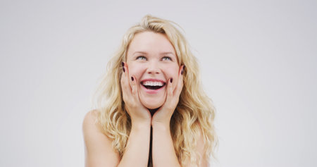 Excited, thinking and woman with daydreaming in studio for happy memory, reflection or good news. Mockup space, girl and thoughtful on white background for inspiration, decision and problem solvingの写真素材