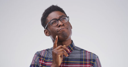 African man, thinking and student in studio with mock up space, confused or doubt on white...