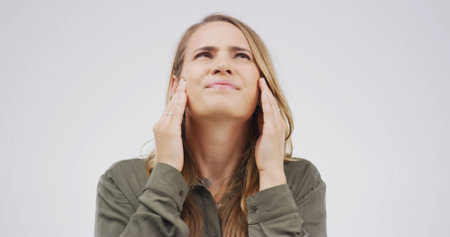 Headache, pain and woman in studio upset with tension, pressure and brain fog on white background....