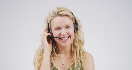 Portrait, woman and headset at call centre in studio for consultation, funny client and contact us. Advisor, laugh and mic for customer service, advice and listening to comic joke on white backgroundの写真素材