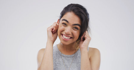 Portrait, funny face and woman with humor, playful or facial expression for comedy, studio or comic. White background, happy and person with reaction for personality, goofy and silly with gestureの写真素材