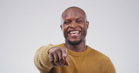 Pointing, you and portrait of black man in studio with smile for selection, decision and choice for winner. Mockup space, happy and person with emoji, gesture and finger for vote on white backgroundの写真素材