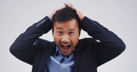 Businessman, shout and surprise in studio portrait for good news, profit or bonus on white background. Person, wow and shock with scream for revenue increase, success and announcement in Cambodiaの写真素材