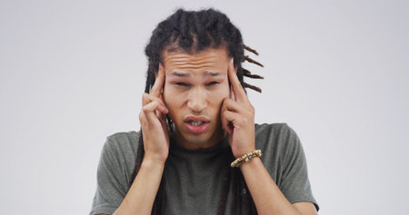 Frustrated man, portrait or headache with stress in studio for pain or strain on a white background. Male person, model or migraine with anxiety or dizziness for pressure or mental health on spaceの写真素材