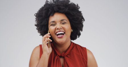 Happy, black woman and laughing with phone call for humor or chat on a white studio background. Female person, African model or smile with mobile smartphone for funny joke, comedy or gossip on spaceの写真素材