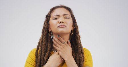Hurt, sick or woman with sore throat on studio space for cold, itchy voice or virus symptoms. Dry, crisis or person choking on white background with flu allergy, thyroid inflammation or neck injuryの写真素材