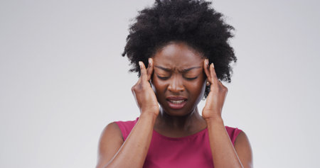 Headache, pain and black woman in studio, stress and frustrated on white background. African person, mockup space and migraine with mental health, anxiety and discomfort with brain fog and burnoutの写真素材