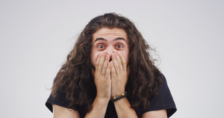 Portrait, shocked and man with emotion, reaction or revelation of announcement for discount or sale. White background, facial expression and person with unexpected news, studio and surprised by infoの写真素材