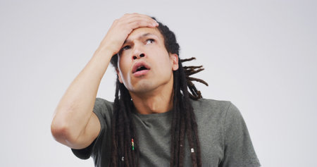 Drama, mistake and reaction with man on studio space for disaster, exam fail or test error. Bad news, crisis and education stress with college or university student isolated on white backgroundの写真素材