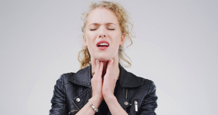 Glands, hurt and woman with pain on studio space for cold, sore throat and virus symptoms. Flu, choke or sick person isolated on white background with allergy, thyroid inflammation or neck injuryの写真素材